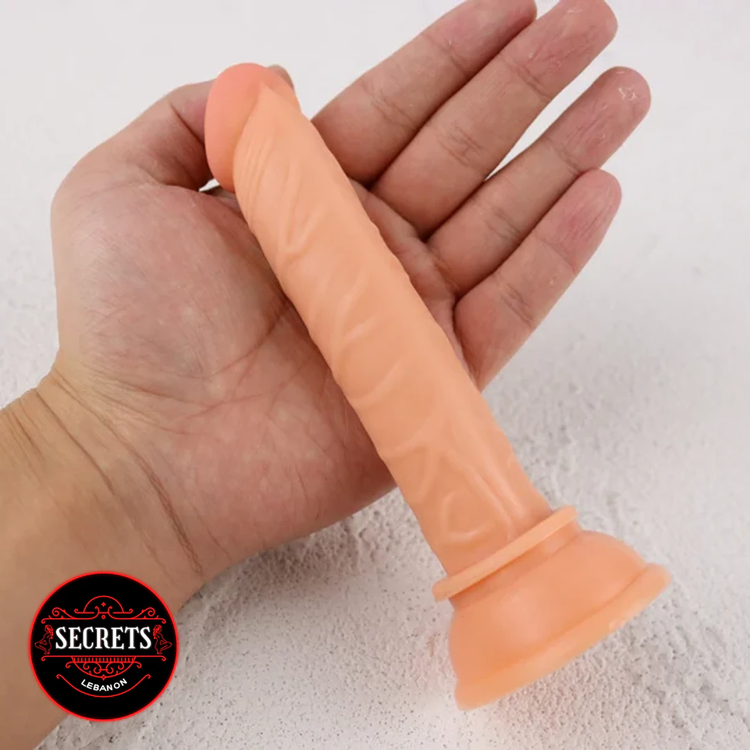 Beginners Jelly Dildo held in palm showing suction cup base flesh tone