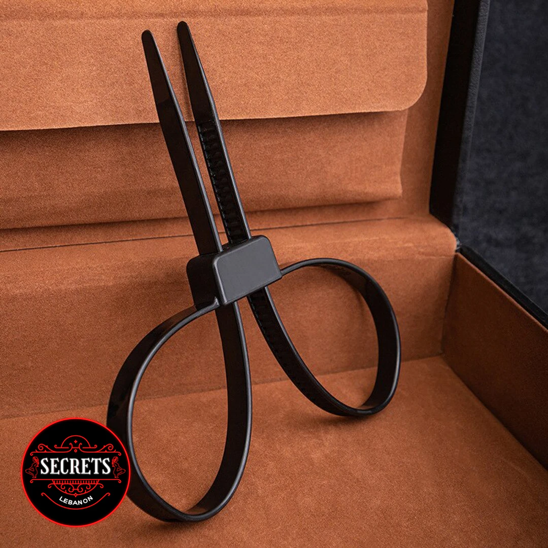Black Zip Tie Bondage Cuffs standing upright against tan suede surface