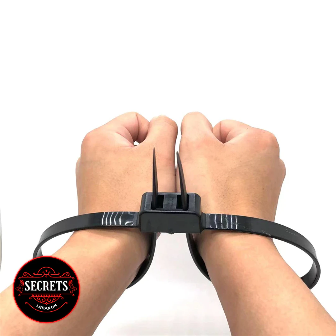 Black Zip Tie Bondage Cuffs securing two wrists together on white background