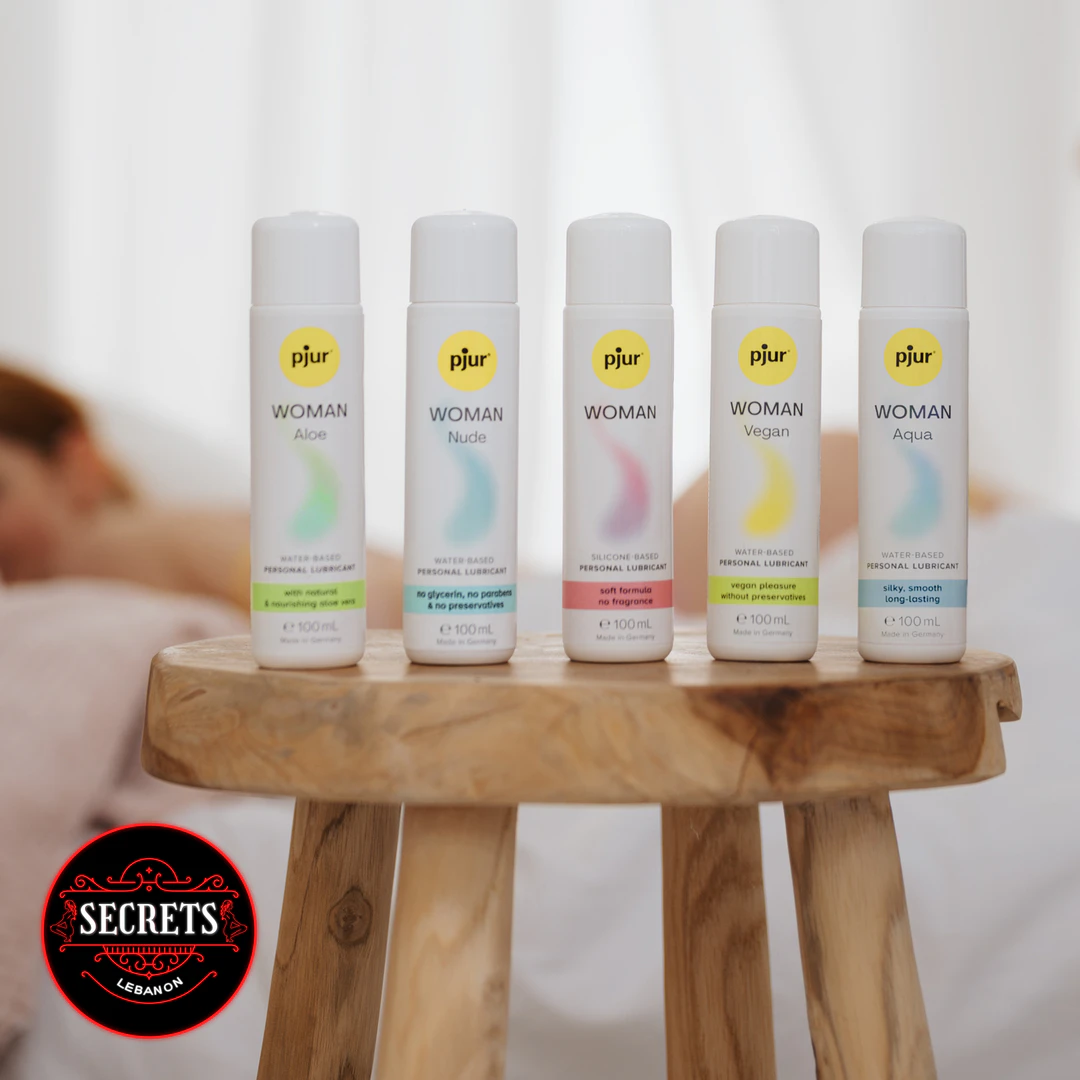 Pjur Woman Aqua Water-Based Lubricant 100ml displayed among four variant bottles on wooden stool