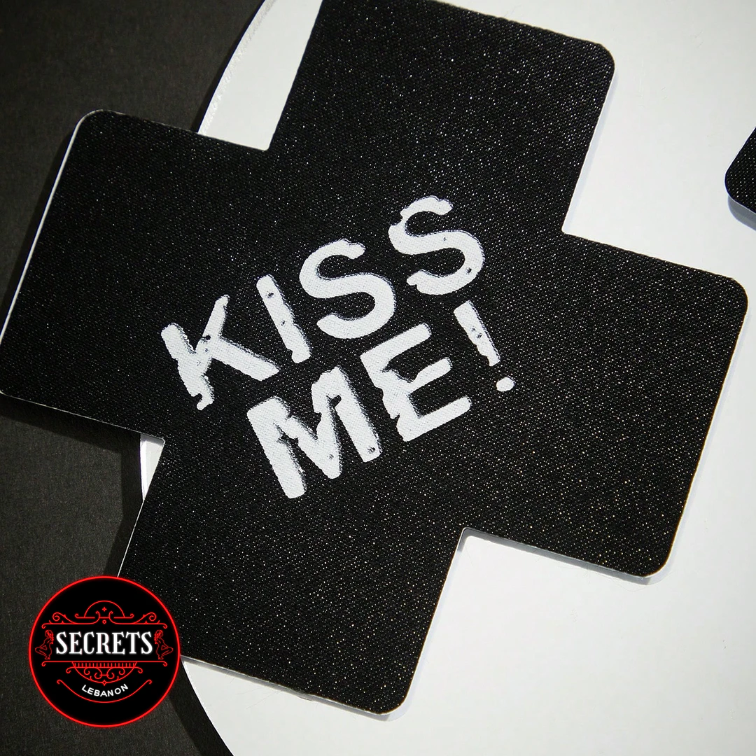 2 Piece Kiss Me Nipple Pasties in black glitter cross shape close-up