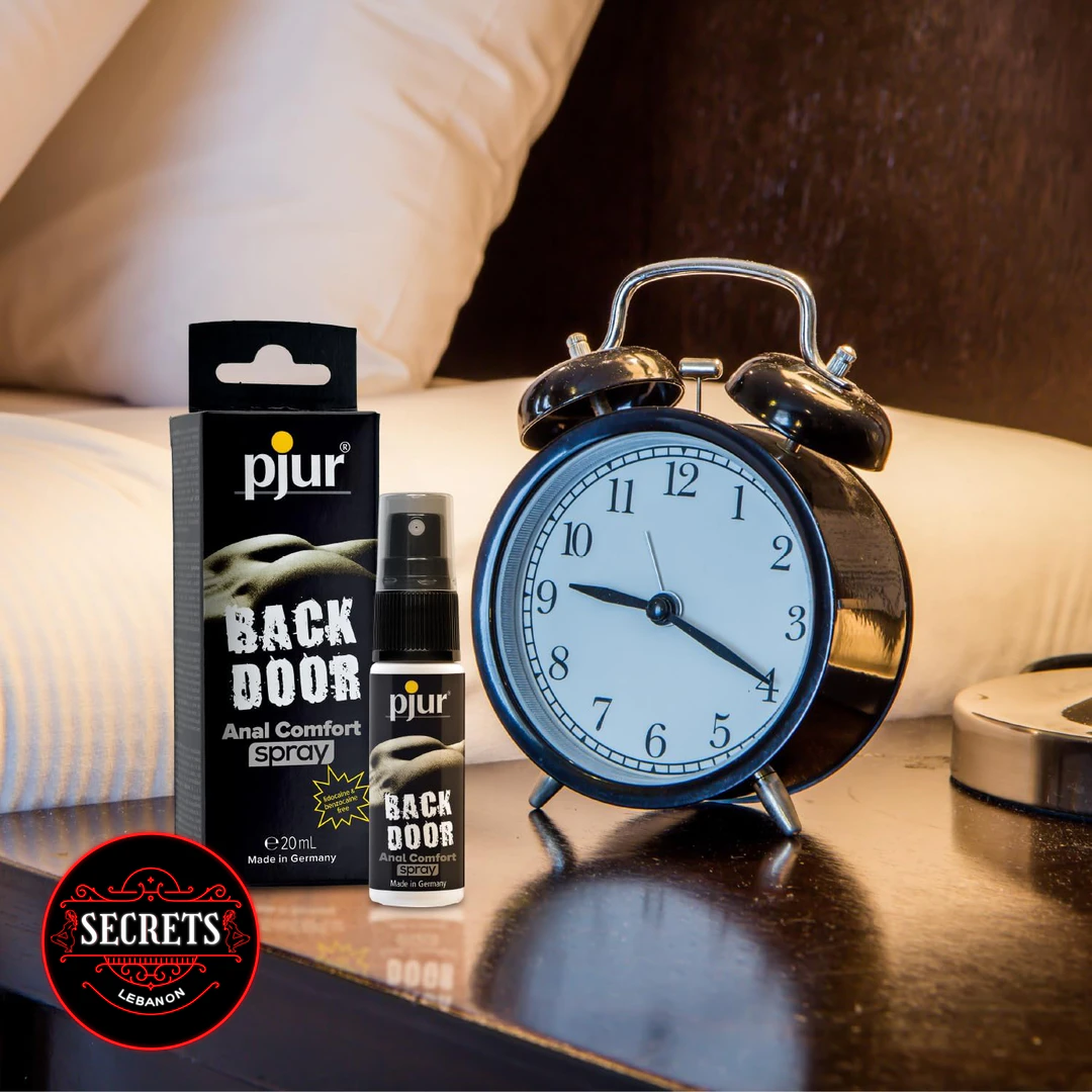 Pjur Back Door Anal Comfort Spray with black box beside bedside alarm clock